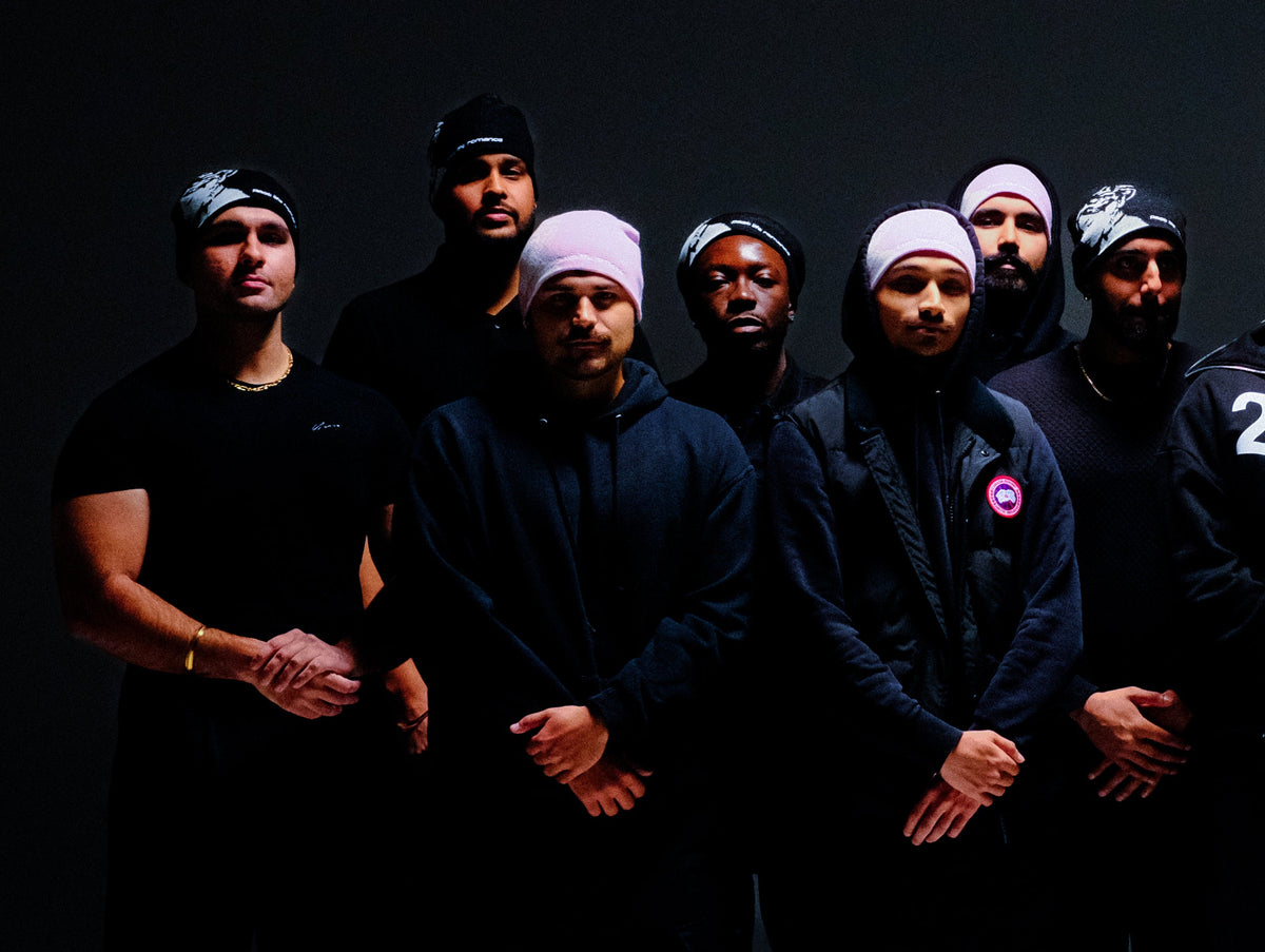 Group of people wearing past life romance hoodies and toques against a dark background